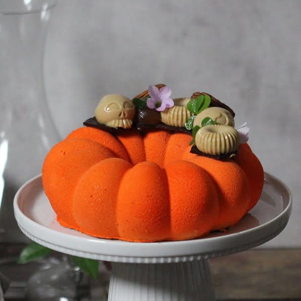 Dags för årets halloweentårta med hjortron, kola och pekannötter. En orange tårta formad som en pumpa fylld med hjortronmousse, kolapannacotta gjord på kondenserad mjölk, på en botten av brownie med pekannötter.